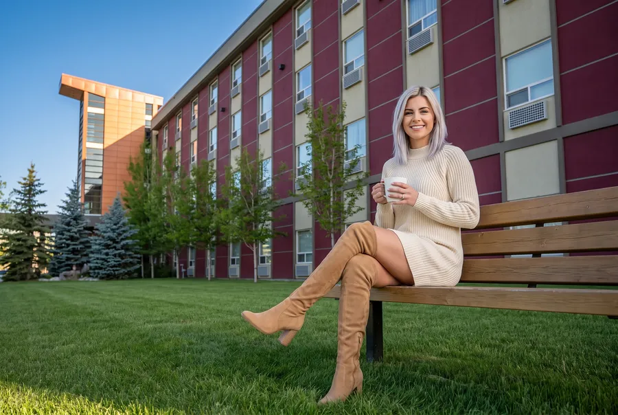 A woman on a bench by the hotel wing